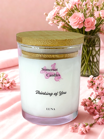 Somerset Candles 'Thinking of You' candle with pink flowers on a soft pink background