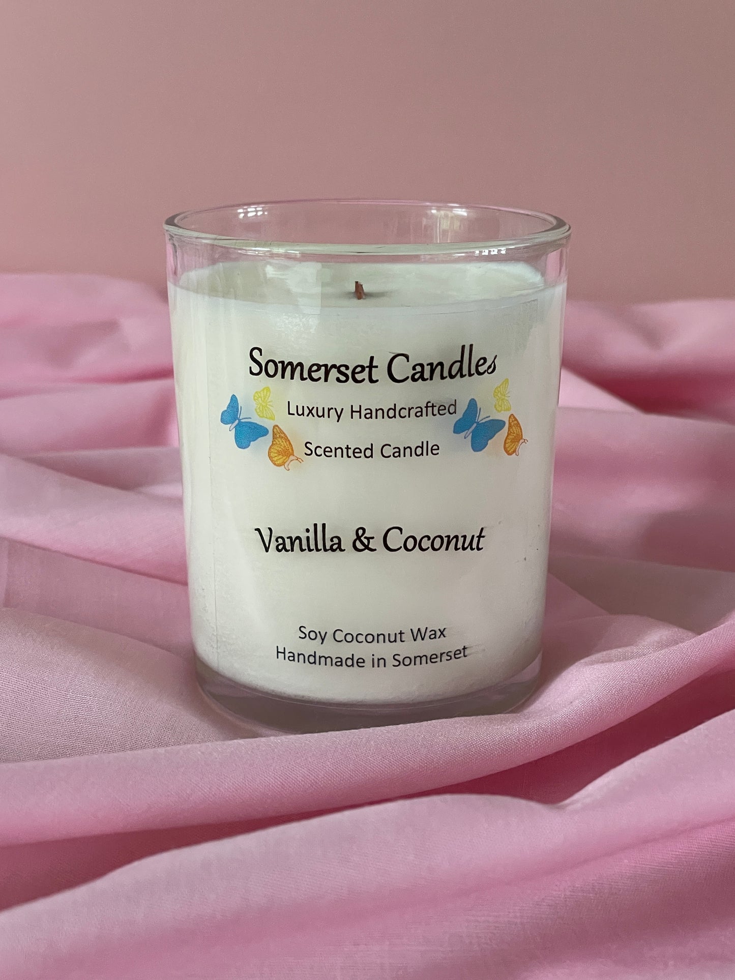 Somerset Candle vanilla and coconut scented candle on a pink fabric background