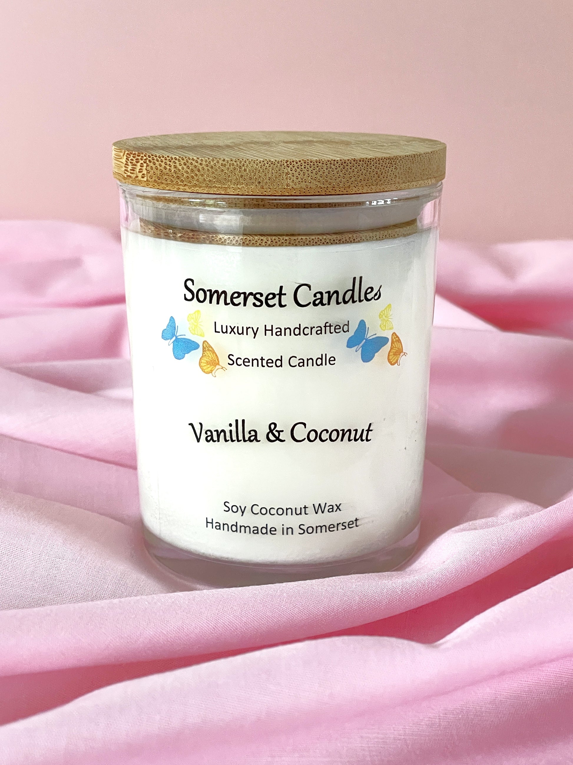 Somerset Candles vanilla and coconut scented candle on a pink fabric background