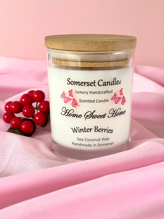 Somerset Candles 'Home Sweet Home' Winter Berries candle on a pink fabric background
