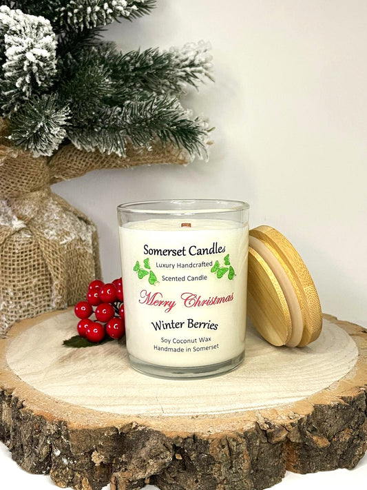 White soy candle in a 7oz clear glass jar with a natural wooden lid. The candle is made from a soy-coconut blend and scented with a fruity scent of winter berries. Above the scent name on the label, several red butterflies are displayed, adding a romantic touch. Clean, minimalist design ideal for gifts, home decor or self-care.