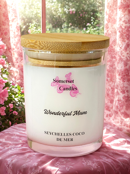 Somerset Candles 'Wonderful Mum' candle with a wooden lid on a pink floral surface.